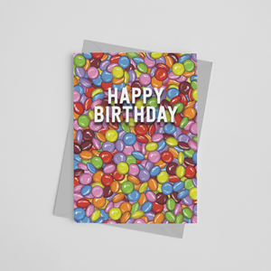Happy Birthday card covered in a hand-drawn illustration of lots of chocolate smarties by Wit and Wisdom UK