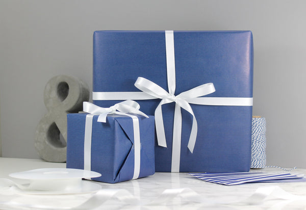 Gift wrapping service by Wit and Wisdom presents wrapped in blue wrapping paper with a white ribbon