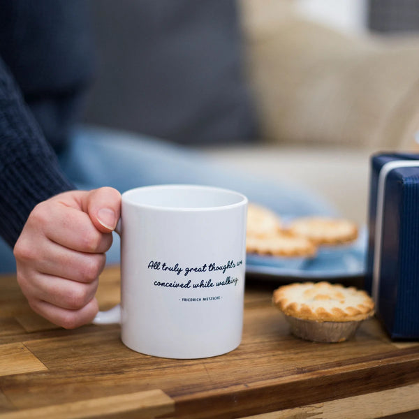 Great Thoughts Walking Quote Mug on a coffee table with mince pies a present.