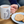 closeup of a mug of tea with a womens cricket design printed on it sitting on a coffee table with a plate of biscuits