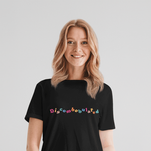 woman wearing a black tshirt with the word discombobulated in bright colours by WitandWisdomUK