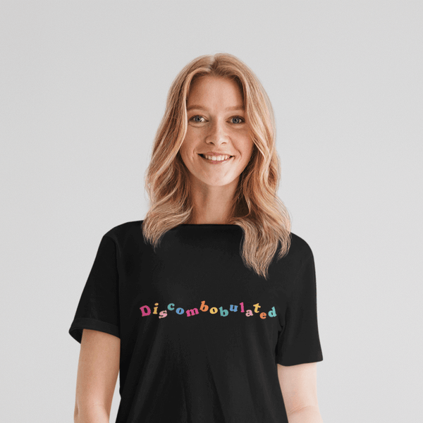 woman wearing a black tshirt with the word discombobulated in bright colours by WitandWisdomUK